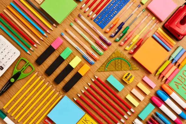 Directly above shot of office and school supplies. Full frame shot of stationery arranged on wooden surface. Knolling Concept.