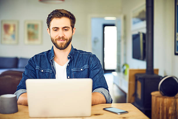 istock Handsome male blogger using laptop at table 599501378