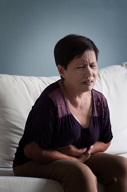 胃が痛いアジアの先輩女性。 - old senior adult women tired ストックフォトと画像