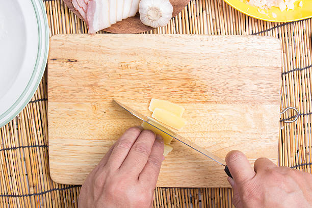 istock Chef cutting cheese with knife before cooking 599502312