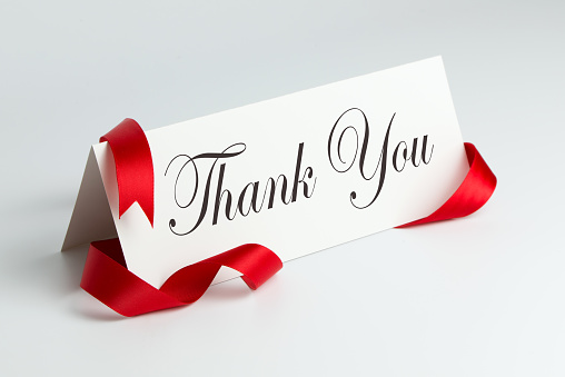 Thank you note with red ribbon over white background