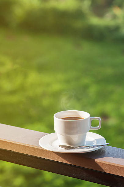 istock White cup of hot coffee on balcony with natural background. 599504200