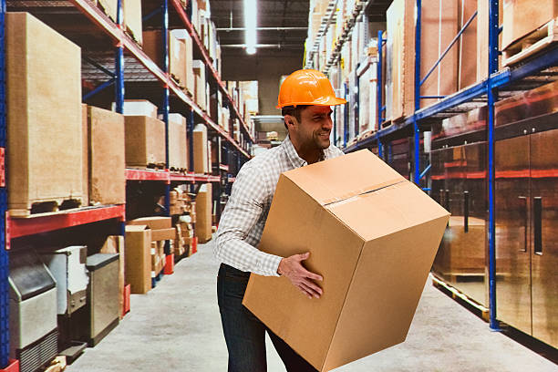 istock Smiling manager holding box in warehouse 599504766