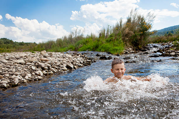 Enfants nageant dans la rivière pendant les vacances, l’été - Photo