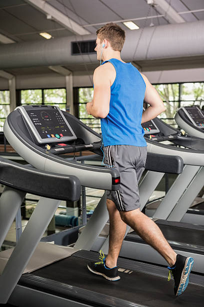 istock Man on treadmill listening to music 599673552