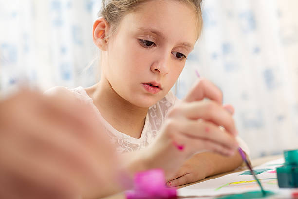 istock Child painting at easel 599675028