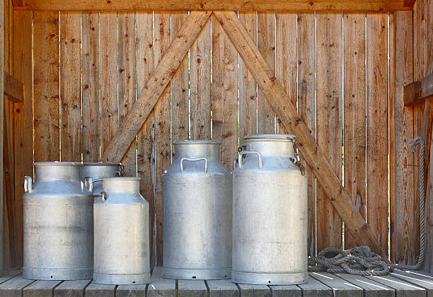 istock Metallic milk containers on a wooden background. Farming 599676412