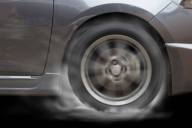 istock Blue car racing spinning wheel burns rubber on floor. 599677094