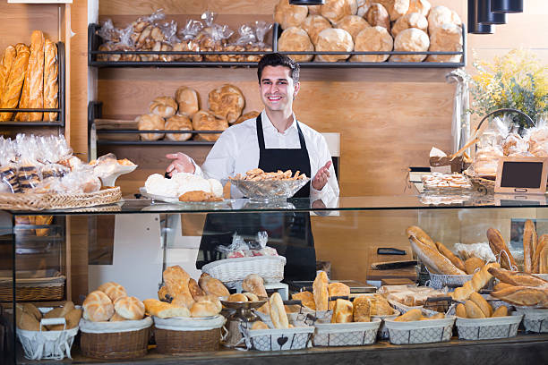 istock Smiling male bakery employee offering pastry 599677292