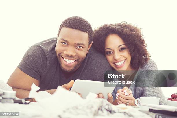 Afro American Happy Couple Using A Digital Tablet Stock Photo - Download Image Now - Couple - Relationship, Digital Tablet, Watching