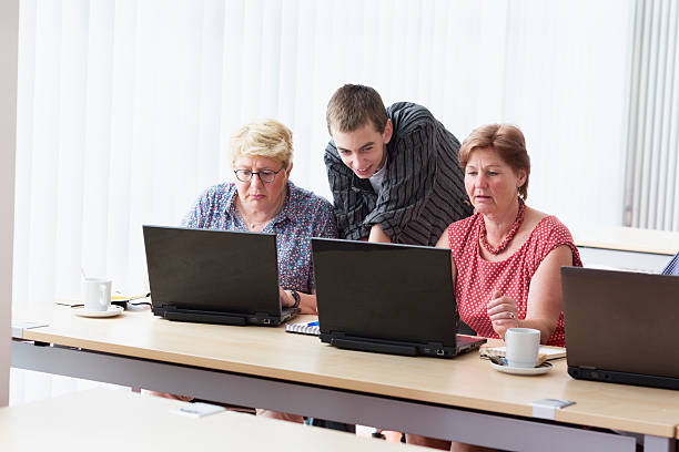 istock young teacher and senior adults learning in computer lab 599678984