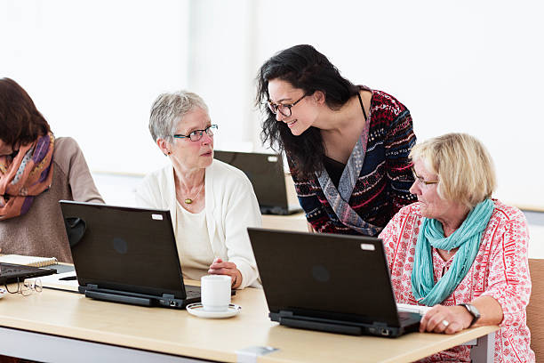 istock young teacher and senior adults learning in computer lab 599679426