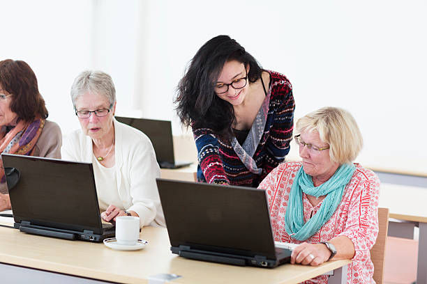 istock young teacher and senior adults learning in computer lab 599679806