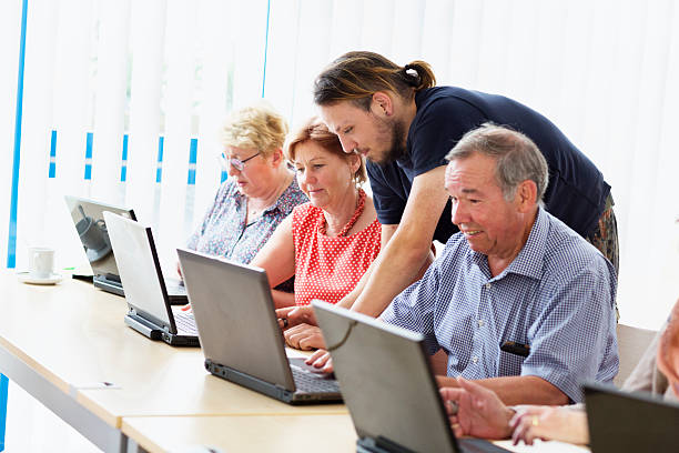 istock young teacher and senior adults learning in computer lab 599681098