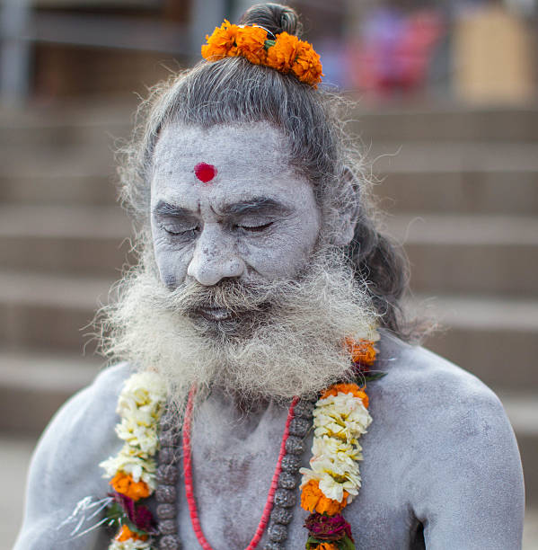 indian holy man meditating at varanasi, india. - sadhu imagens e fotografias de stock