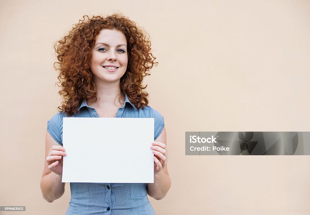 Happy woman showing white banner Beautiful woman showing blank white sign Holding Stock Photo