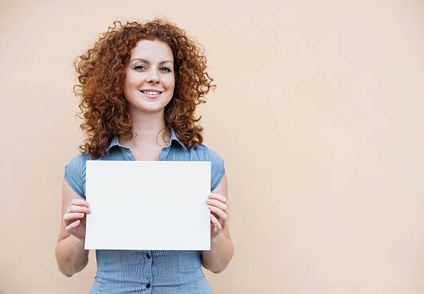 Happy woman showing white banner Beautiful woman showing blank white sign placard photos stock pictures, royalty-free photos & images