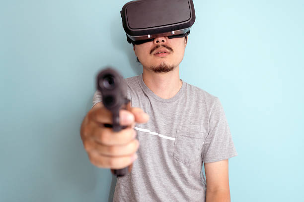 istock Man with a head mounted display holding a gun 599684186