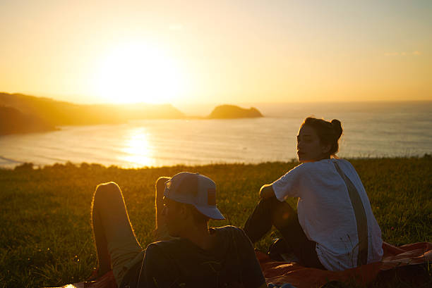 istock young hip couple looking at sunset from  hill over sea 599684406