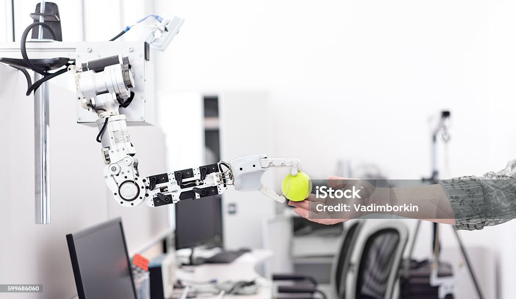 la mano del robot sostiene los objetos dibujados a la mano de un hombre - Foto de stock de Robot libre de derechos
