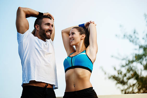 casal feliz se exercitando ao ar livre. - couple stretching running jogging - fotografias e filmes do acervo
