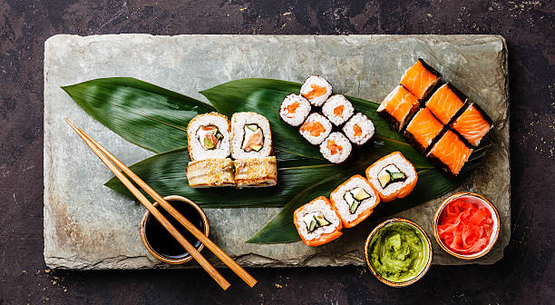 sushi set roule sur feuille verte de bambou - susi photos et images de collection