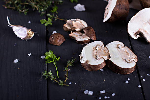istock Fresh mushrooms with spices and herbs on a black board. 599694338