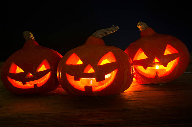 istock Scary halloween pumpkins on dark background 599696398