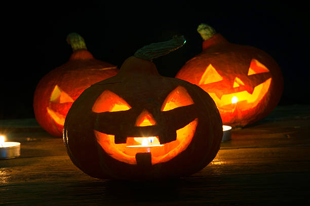 istock Scary halloween pumpkins on dark background 599697828
