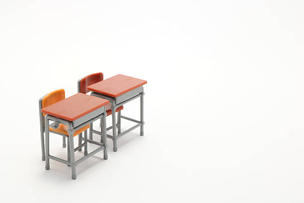 istock Two miniature school desks on white background. 599698530