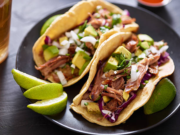 istock pork carnita tacos close up with lime wedges 599704384