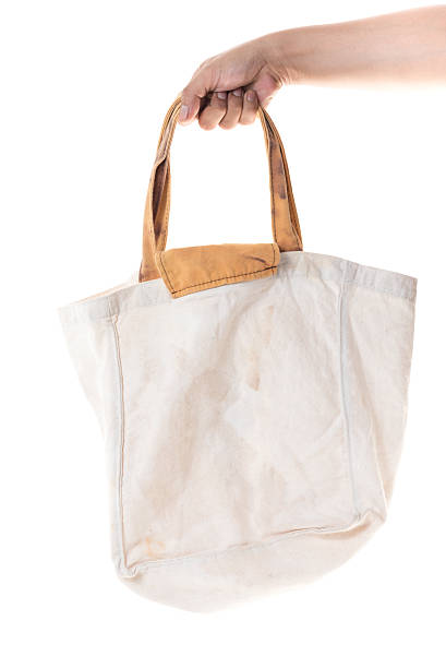 istock Hand holding grunge cotton bag on white background 599704550