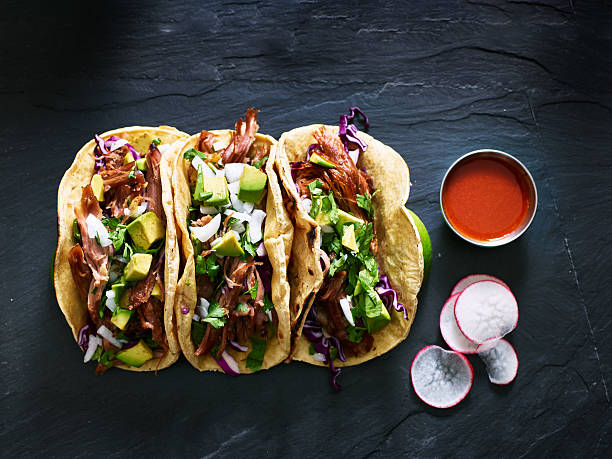 tre carnitas di maiale messicano tacos composizione piatta laici - tabasco sauce foto e immagini stock