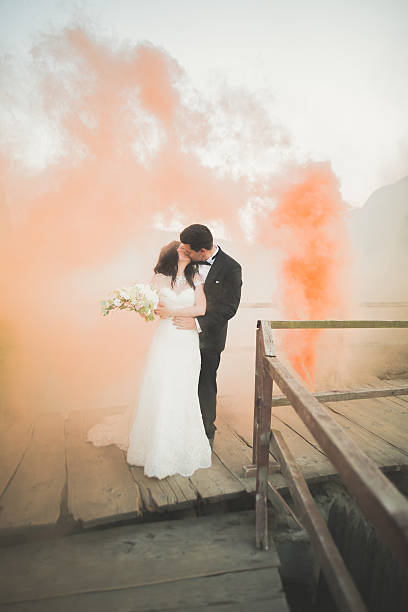 istock Wedding couple posing near rocks with colored smoke behind them 599706176