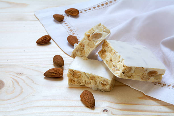 istock torrone or white nougat with almonds and napkin on wood 599706288