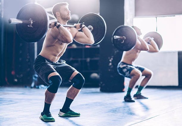 No pain, no gain! Young men exercising deadlift in gym. Professional athletes. Wearing sports clothing. crossfit chalk weightlifting weight training stock pictures, royalty-free photos & images