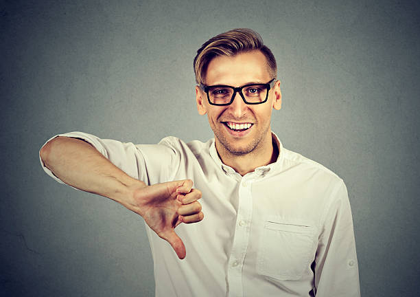 istock sarcastic man showing thumbs down sign happy 599714256