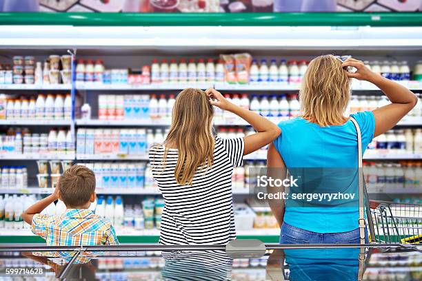 Family Chooses Dairy Products In Shop Stock Photo - Download Image Now - Confusion, Supermarket, Choice