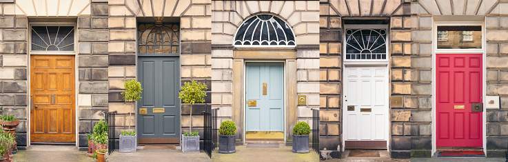 A selection of five colourful Georgian front doors in Edinburgh's New Town, each with different pattered glass above the door.