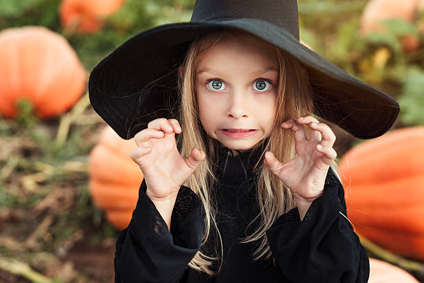 Little witch Cute little witch doing scary face. Halloween theme. halloween costume stock pictures, royalty-free photos & images