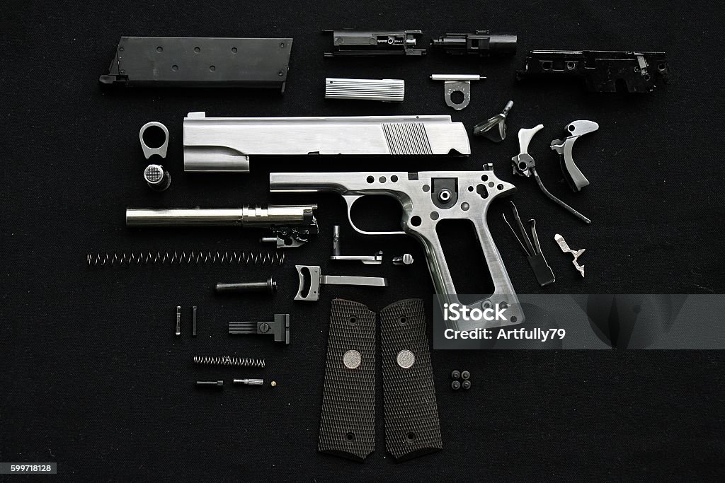 Disassembled handgun Disassembled handgun on black background Gun Stock Photo
