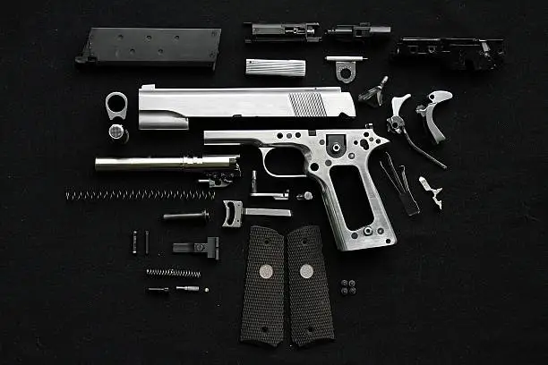 Disassembled handgun on black background