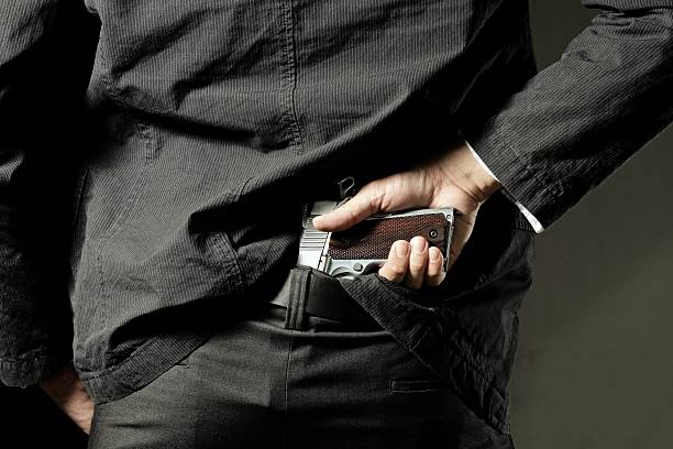 killer or gangster concealing gun - vengeful imagens e fotografias de stock