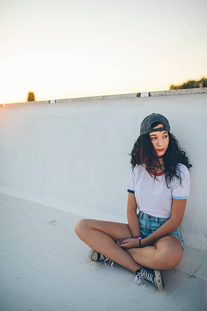 istock Beautiful young woman sitting on rooftop 599751600