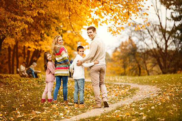 istock Family walking in autumn park 599752246