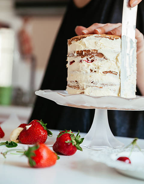 istock Woman Carefully Icing The Cake 599756778