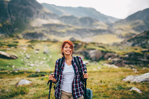 Happy female hiker standing in the beautiful mountain.