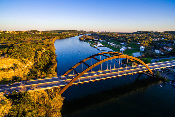 Aerial Pennybacker Bridge at Sunset Austin Texas Hill Country Aerial Pennybacker Bridge at Sunset Austin Texas Hill Country during a clear sky evening the sun sets behind the hills and casts a perfect golden hour glow on the Texas Hill country and the 360 Bridge or Pennybacker Bridge with the Austin Texas skyline cityscape in the background west lake stock pictures, royalty-free photos & images