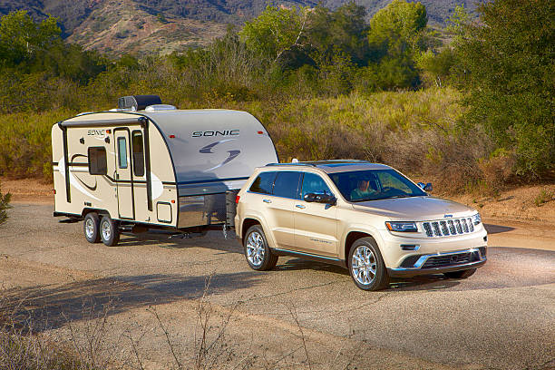 jeep zieht ein schall-camper horizontal - jeep grand cherokee stock-fotos und bilder