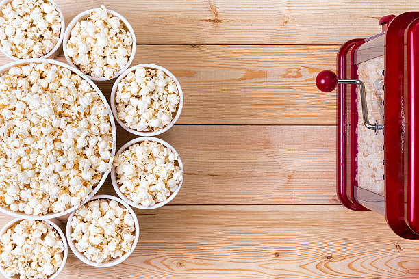 Bowls of fresh popcorn alongside a machine